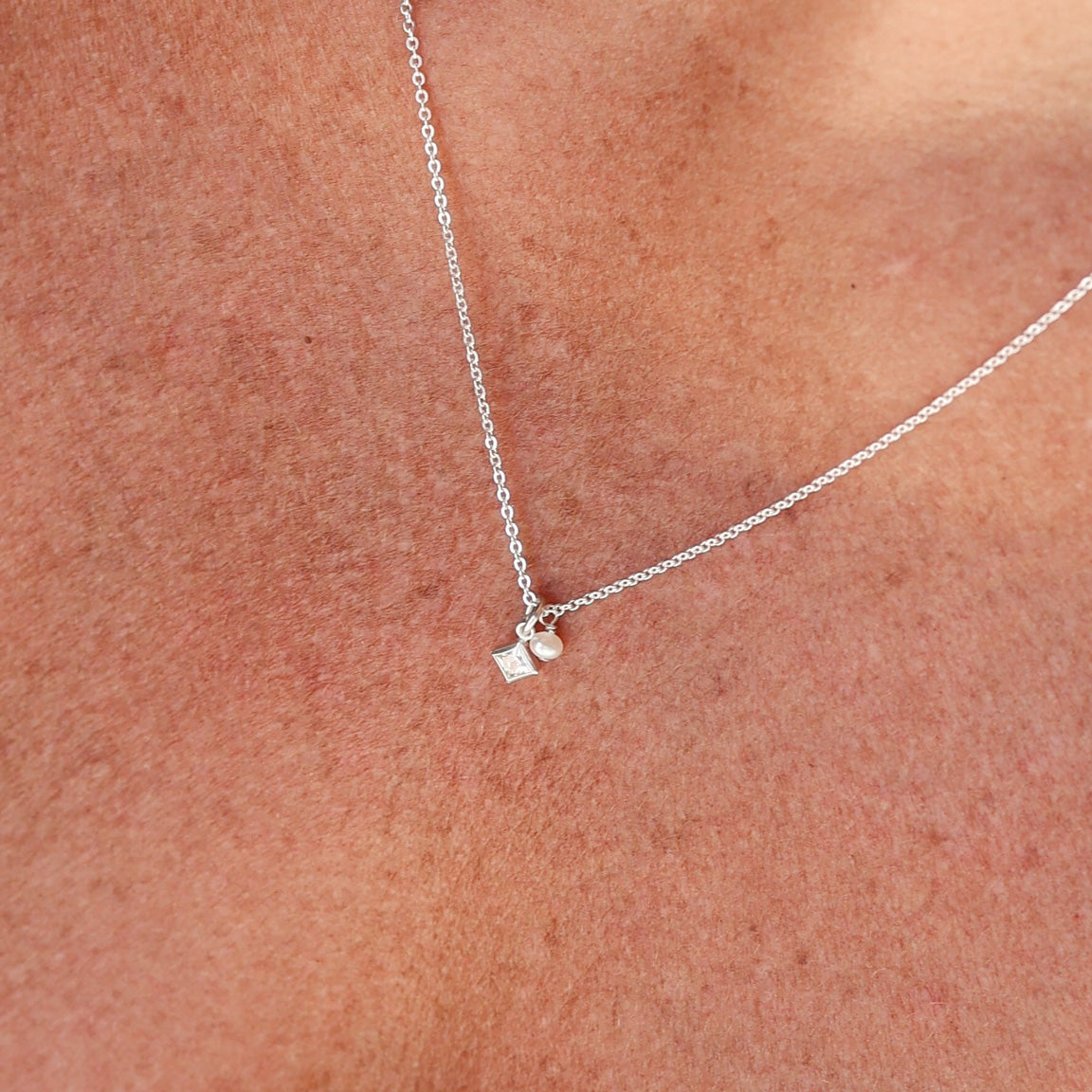 Two necklaces with square pendants on a light background - KBN Jewellery - Birthstone Necklace - Pearl Necklace
