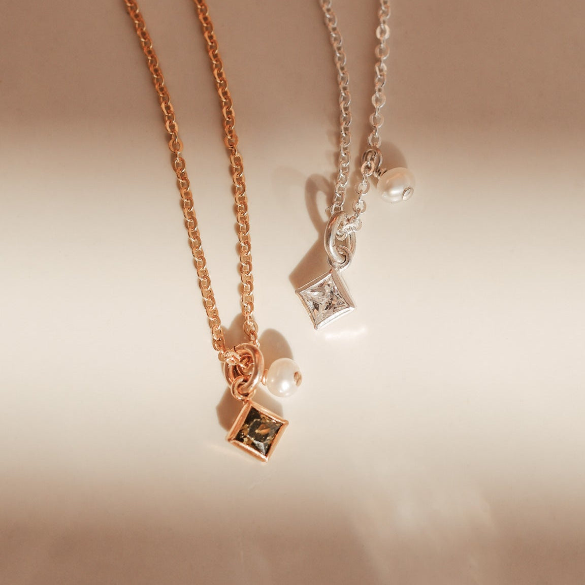 Two necklaces with square pendants on a light background - KBN Jewellery - Birthstone Necklace - Pearl Necklace